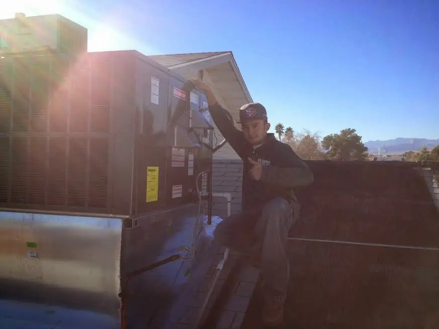 HVAC technician performing Heat Pump Repair on a rooftop unit in Caernarvon